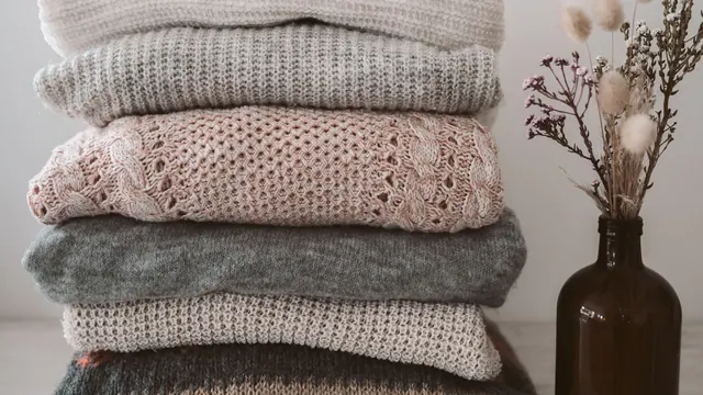 Folded knitted jumpers in soft neutral colours